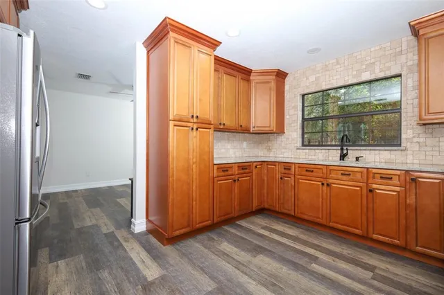 a kitchen with stainless steel appliances granite countertop a refrigerator microwave and sink