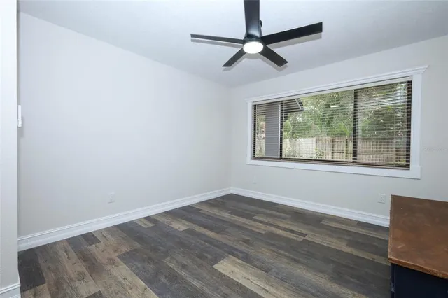 a room with wooden floor and ceiling fan