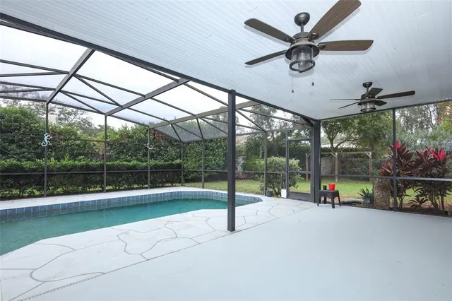 a view of an empty room with a ceiling fan and window