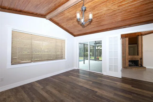 a view of wooden floor in an empty room with a window