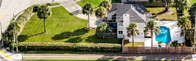 a view of an empty room with wooden floor a fireplace and a window