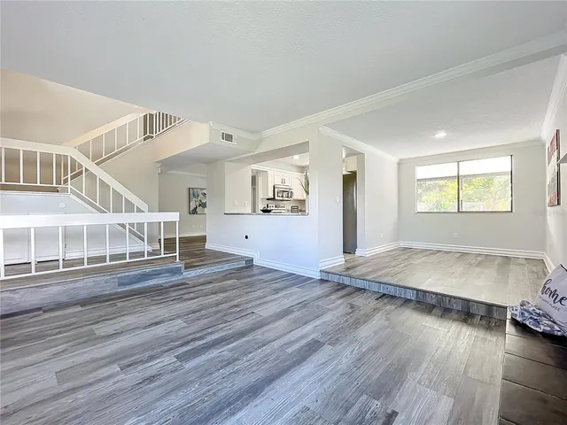 a view of an empty room with wooden floor and closet