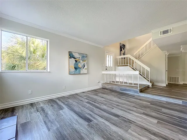 a view of a hallway with wooden floor and entryway