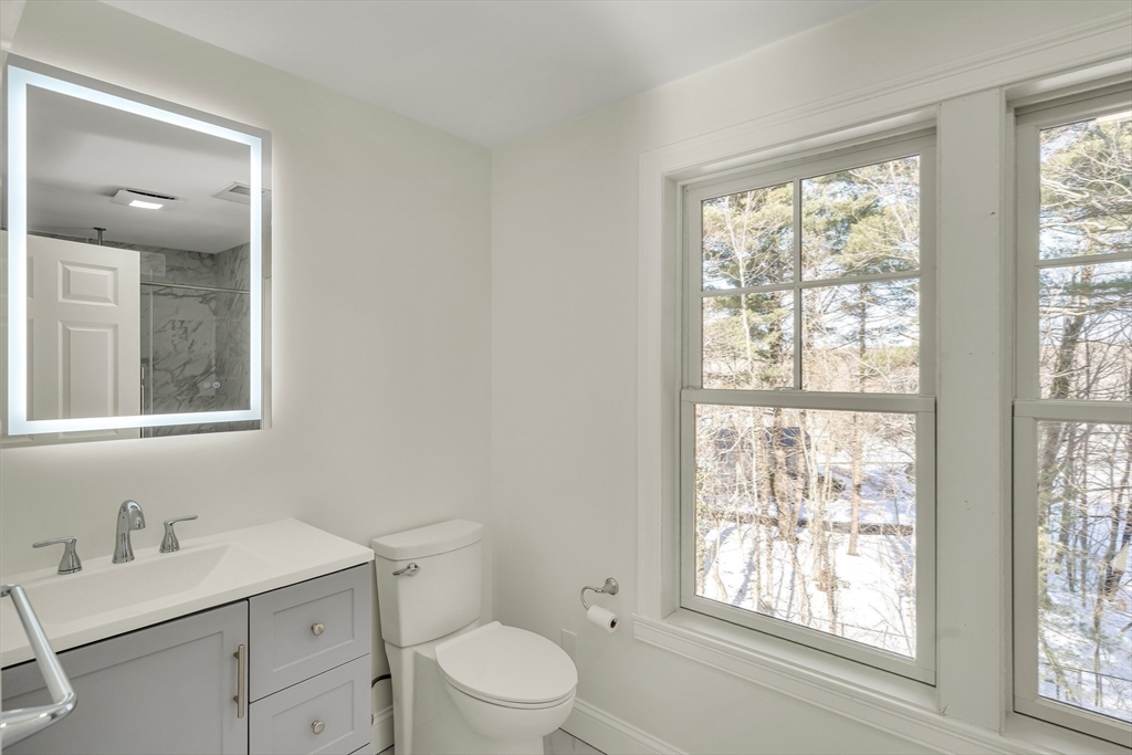510 Common Street Walpole, MA 02081 - Photo 25 of 35 a bathroom with a toilet a sink a vanity a window and mirror