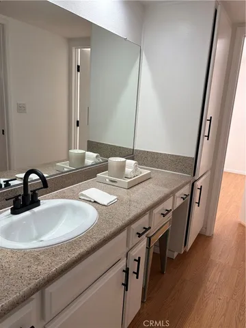 a bathroom with a granite countertop sink and a mirror