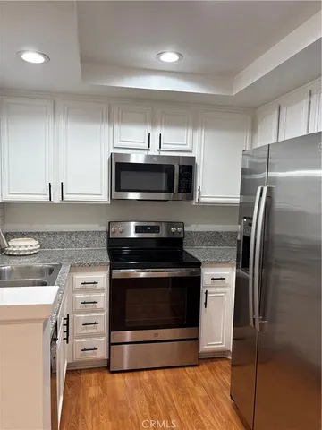 a kitchen with cabinets and stainless steel appliances