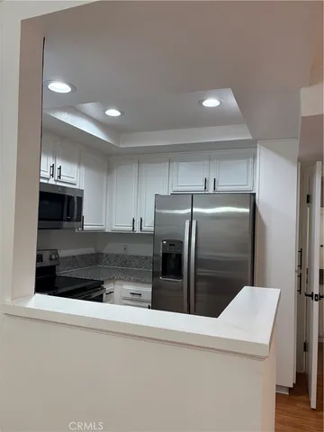 a kitchen with stainless steel appliances granite countertop a refrigerator and a stove