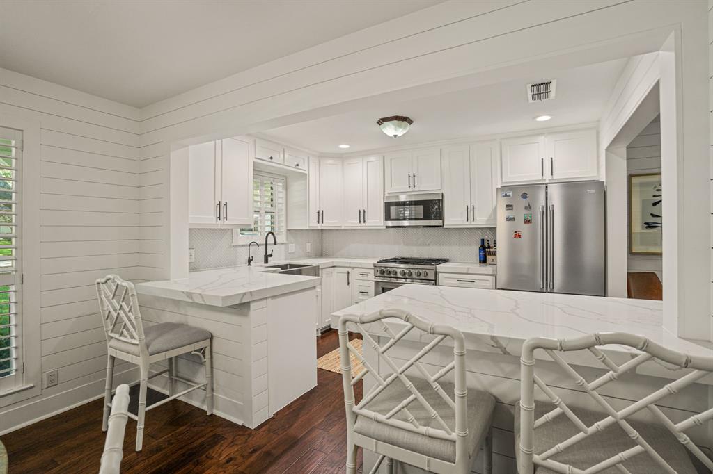 4529 Cloudview Road Fort Worth, TX 76109 - Photo 7 of 26 a kitchen with stainless steel appliances a sink a stove a refrigerator cabinets and a dining table