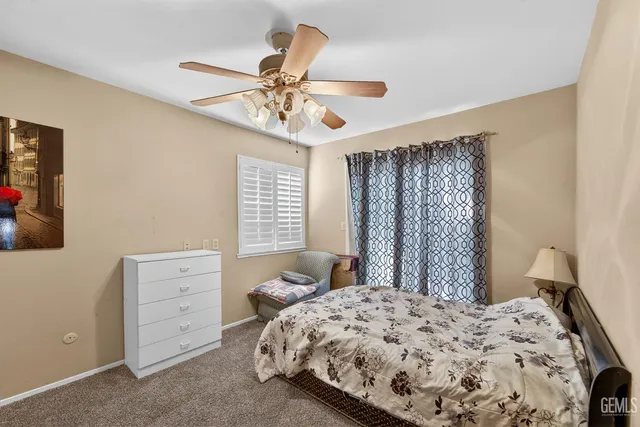 a view of a bedroom with a bed and a chandelier fan