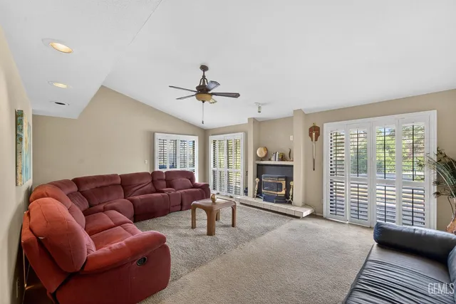 a living room with furniture ceiling fan and a fireplace