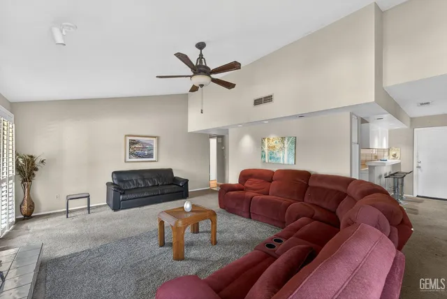 a living room with furniture a ceiling fan and a wooden floor