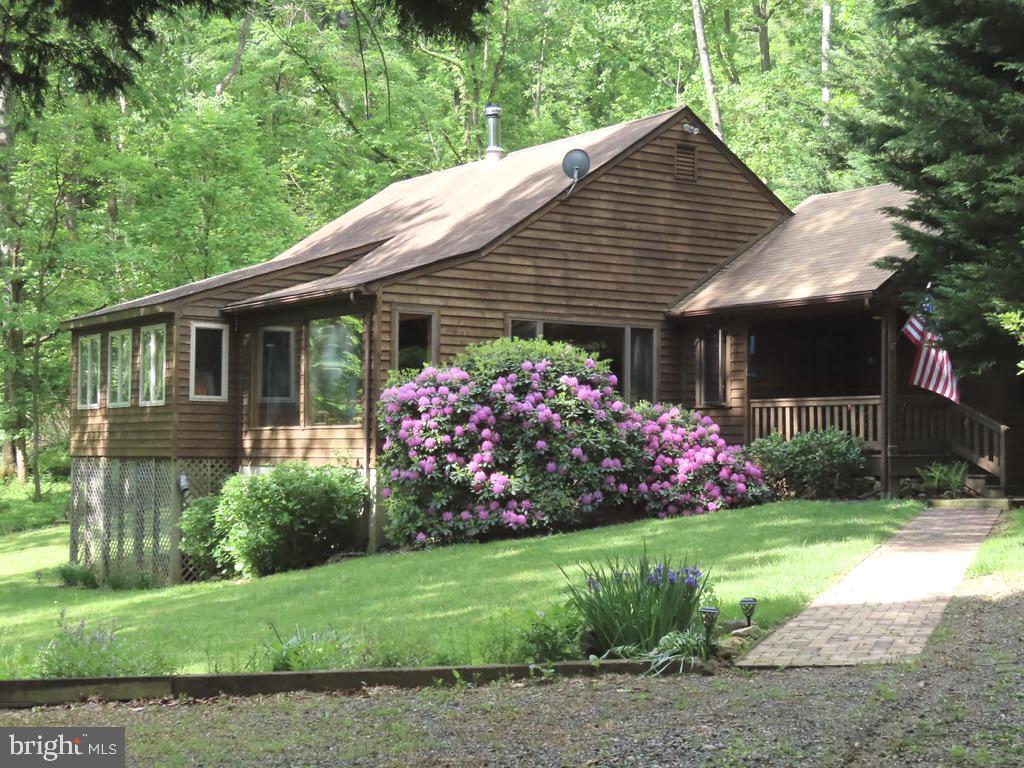 87 Woodland Lane Huntly, VA 22640 - Photo 1 of 35 a front view of a house with a garden