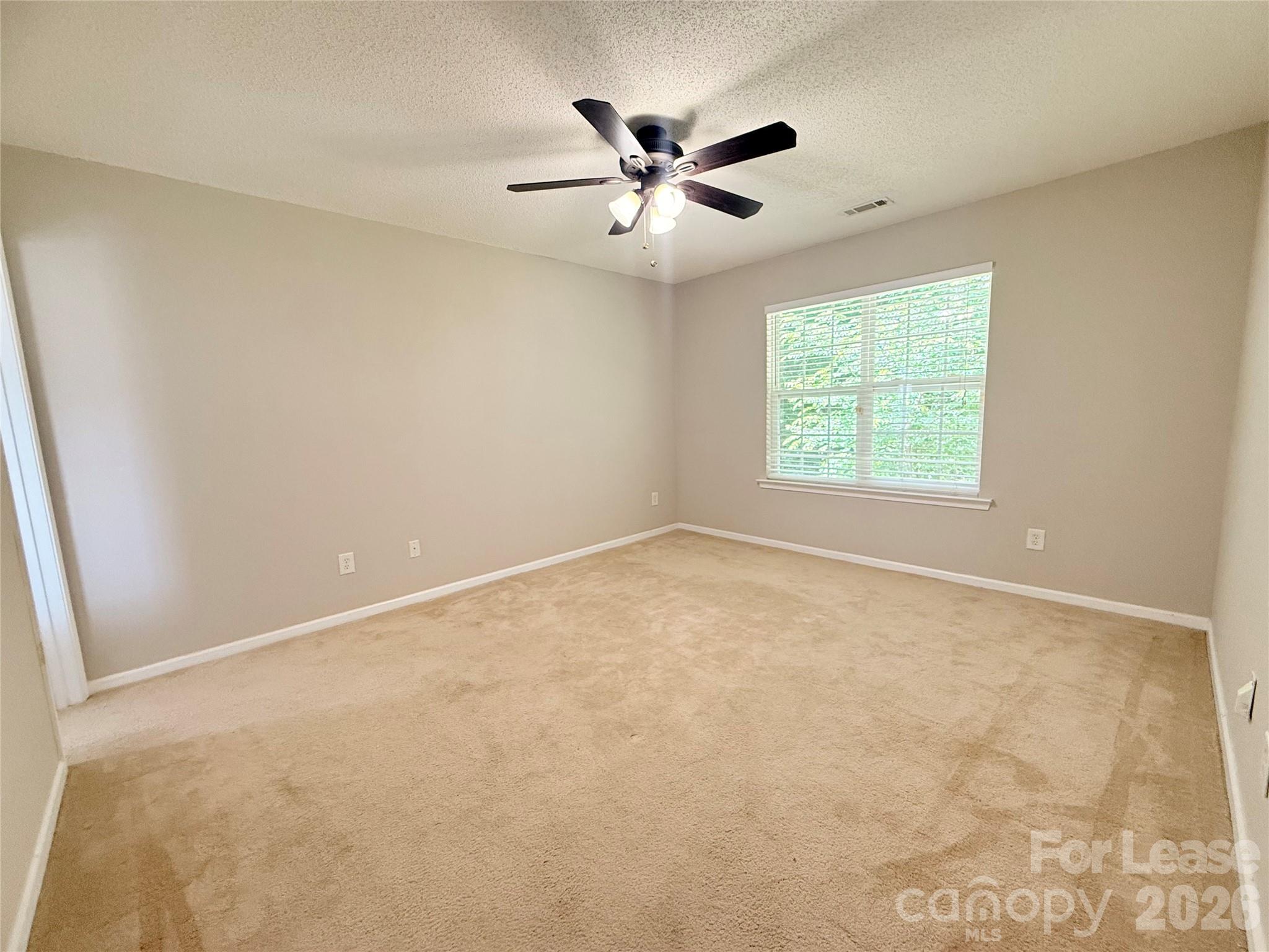 10553 Gold Pan Road Charlotte, NC 28215 - Photo 7 of 15 an empty room with a ceiling fan and window