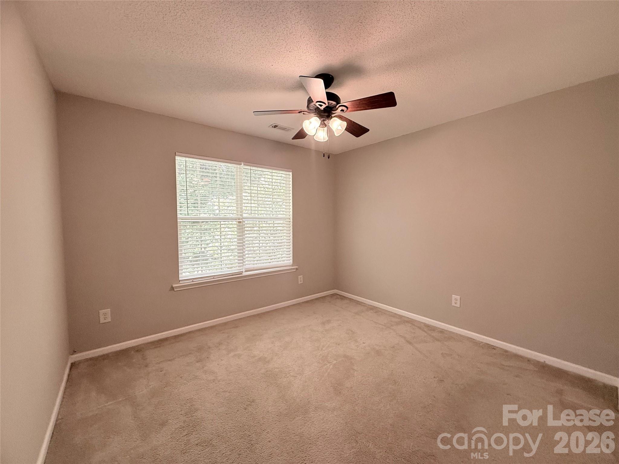 10553 Gold Pan Road Charlotte, NC 28215 - Photo 8 of 15 an empty room with a window and a fan