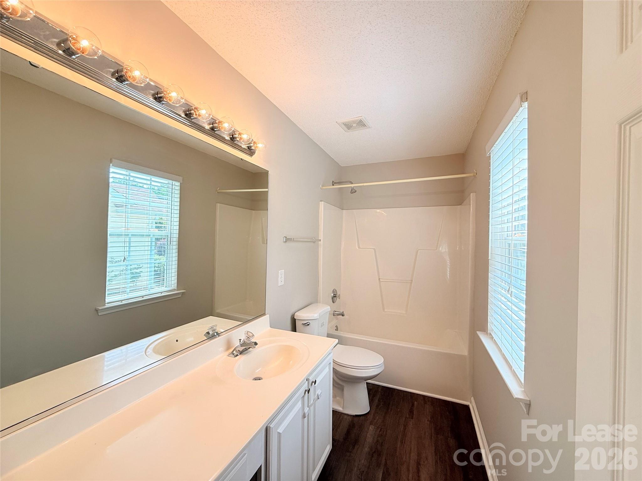 10553 Gold Pan Road Charlotte, NC 28215 - Photo 10 of 15 a bathroom with a sink a toilet a tub and a window
