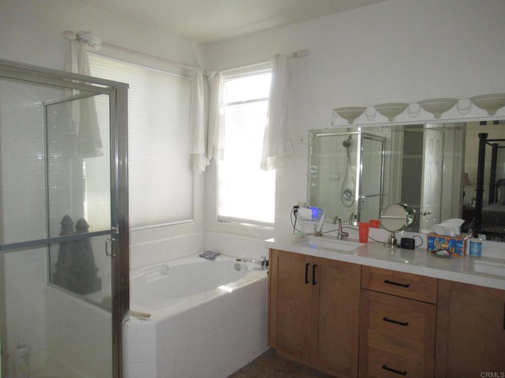 6033 Patmos Way Oceanside, CA 92056 - Photo 12 of 41 a bathroom with a tub sink shower and mirror