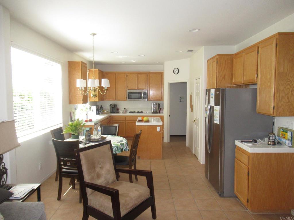6033 Patmos Way Oceanside, CA 92056 - Photo 15 of 41 a dining room with furniture a window and kitchen view