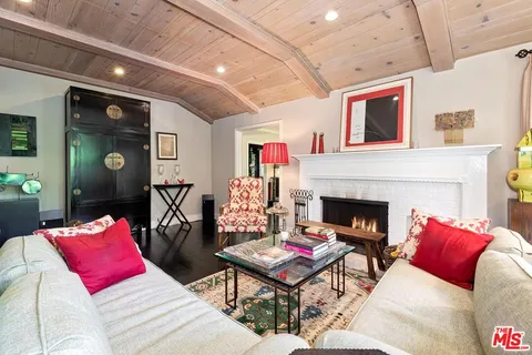 a living room with furniture floor to ceiling window and wooden floor