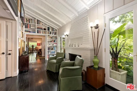a bedroom with a bed a table and large mirror