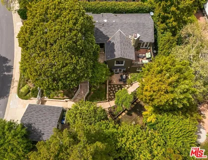 an aerial view of residential houses with outdoor space and trees