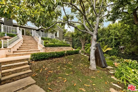 a view of a house with backyard sitting area and garden