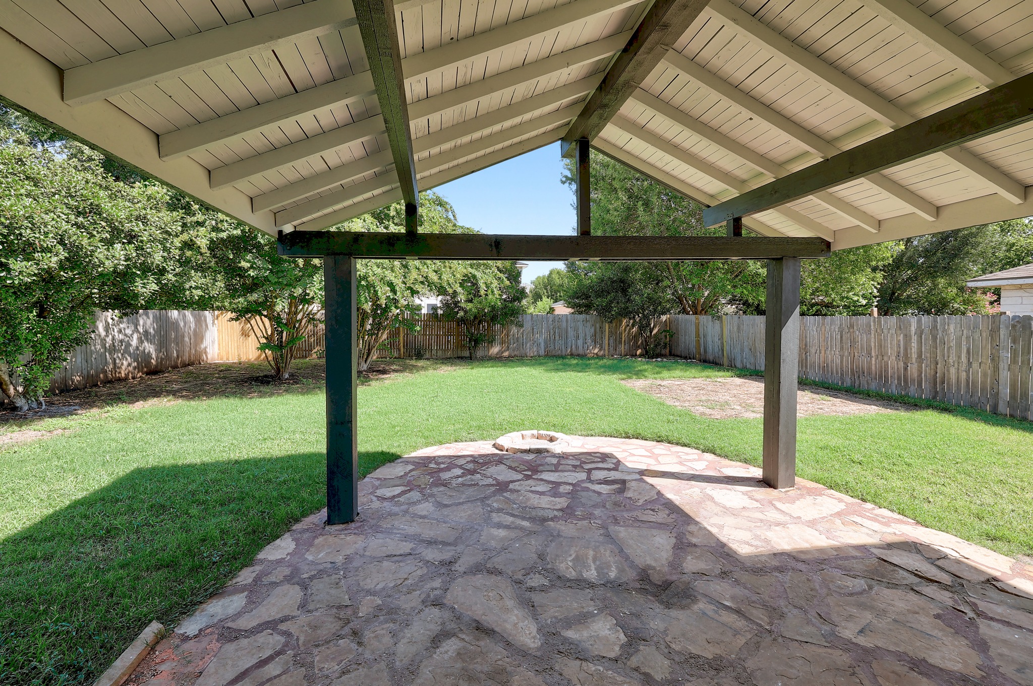 709 Los Robles Road Leander, TX 78641 - Photo 2 of 26 An inviting covered patio featuring flagstone paving leads to a generous, fenced backyard with a built-in fire pit.