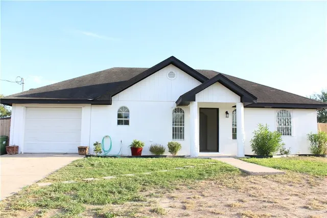a view of a house with backyard and garden