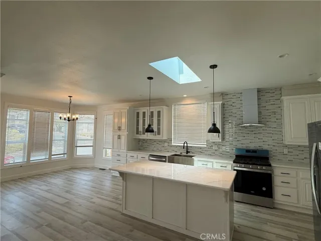 a large kitchen with kitchen island a sink stainless steel appliances and cabinets