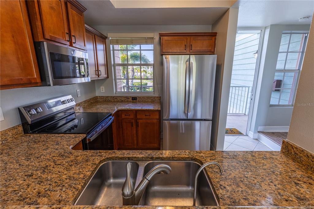 3210 Mangrove Point Drive Ruskin, FL 33570 - Photo 9 of 48 a kitchen with stainless steel appliances granite countertop a refrigerator a stove and a sink with wooden floor