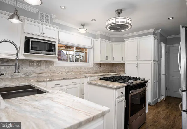 a kitchen with stainless steel appliances a stove sink microwave and cabinets