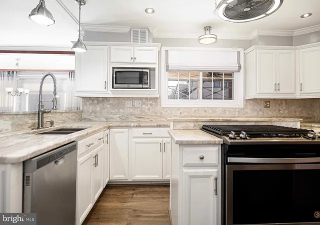 a kitchen with stainless steel appliances granite countertop a stove sink and cabinets