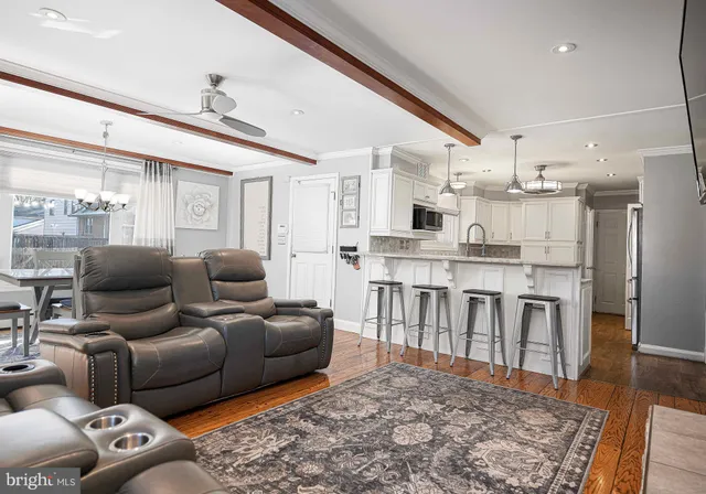 a living room with stainless steel appliances furniture and a rug