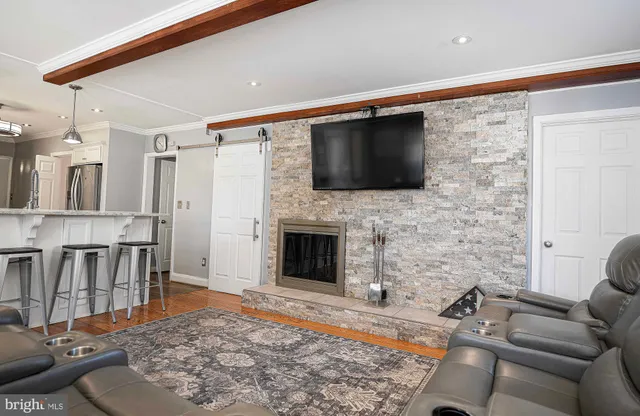 a living room with furniture a flat screen tv and a fireplace