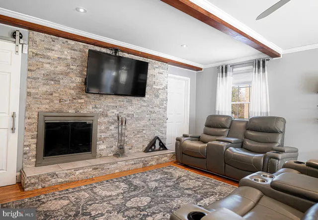 a living room with furniture a flat screen tv and a fireplace