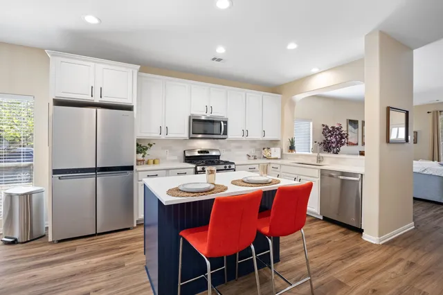 a kitchen with stainless steel appliances a refrigerator stove microwave and cabinets