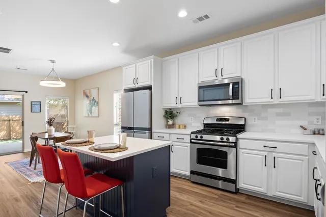 a kitchen with a sink stove and white cabinets