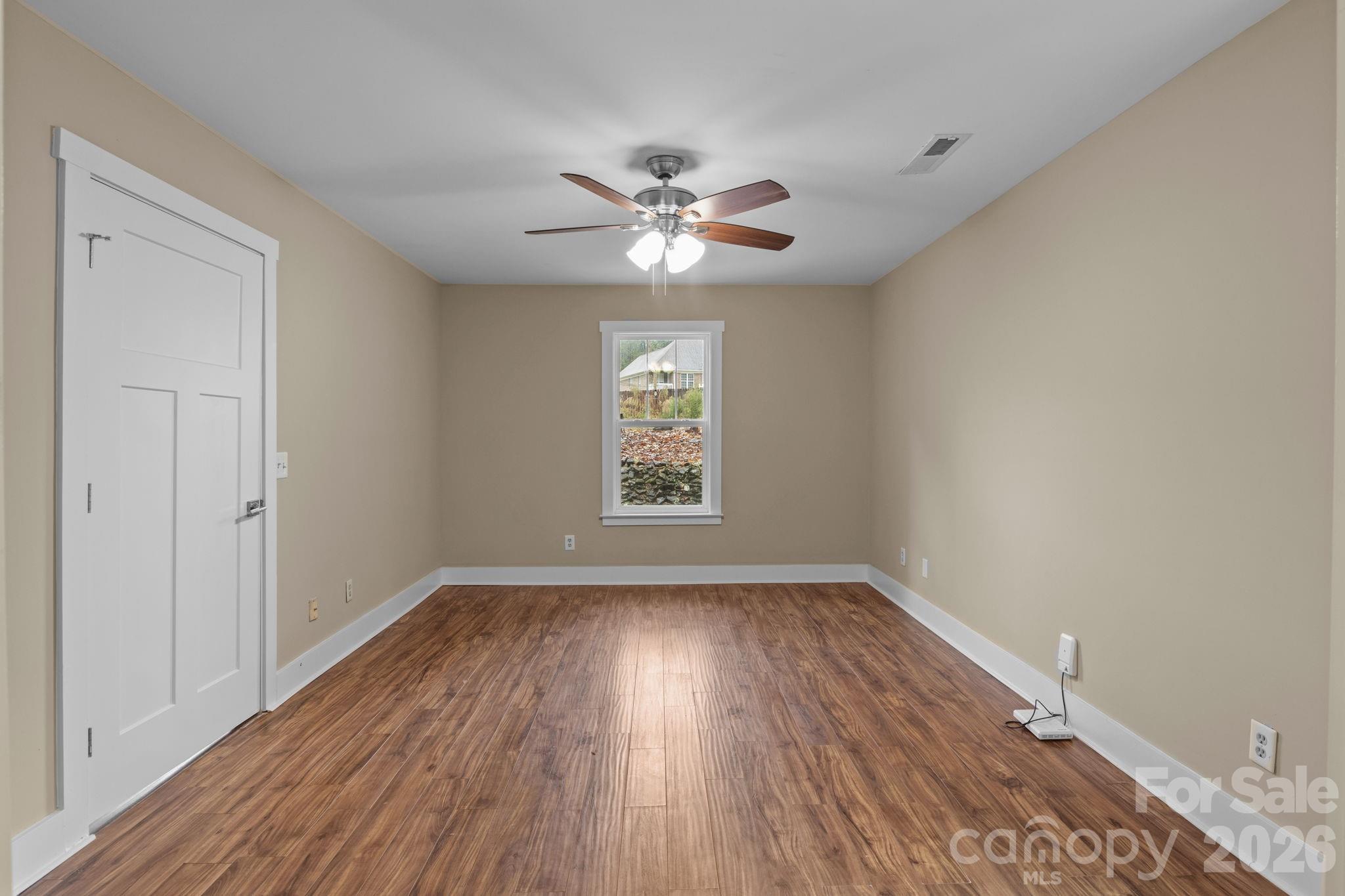996 Cornelius Road Mooresville, NC 28117 - Photo 13 of 26 a view of an empty room with window and wooden floor