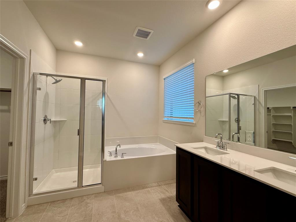 2025 Eugene Street Anna, TX 75409 - Photo 13 of 32 a bathroom with a double vanity sink mirror and shower