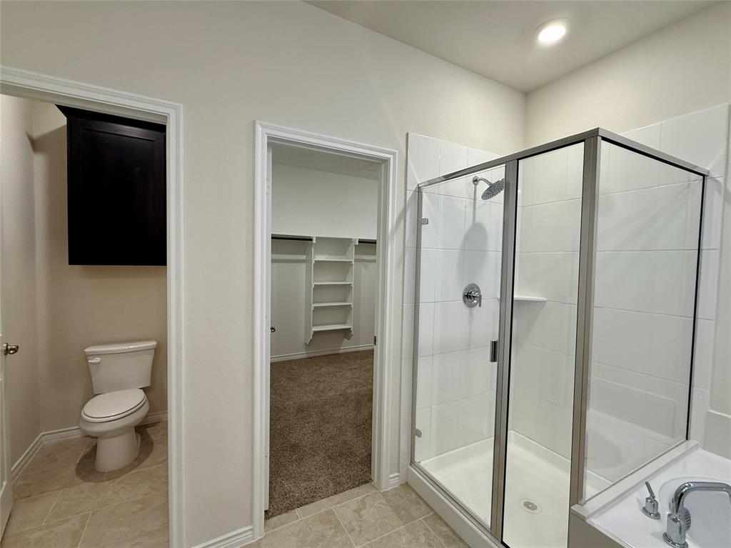 2025 Eugene Street Anna, TX 75409 - Photo 14 of 32 a bathroom with a shower and a toilet