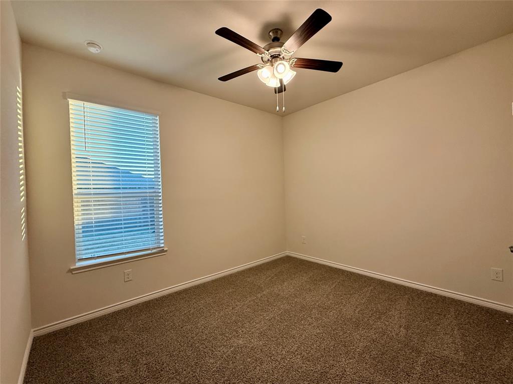2025 Eugene Street Anna, TX 75409 - Photo 17 of 32 an empty room with a window and a ceiling fan