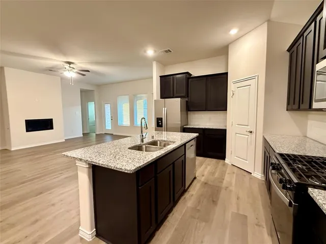 a kitchen with a center island appliances and cabinets