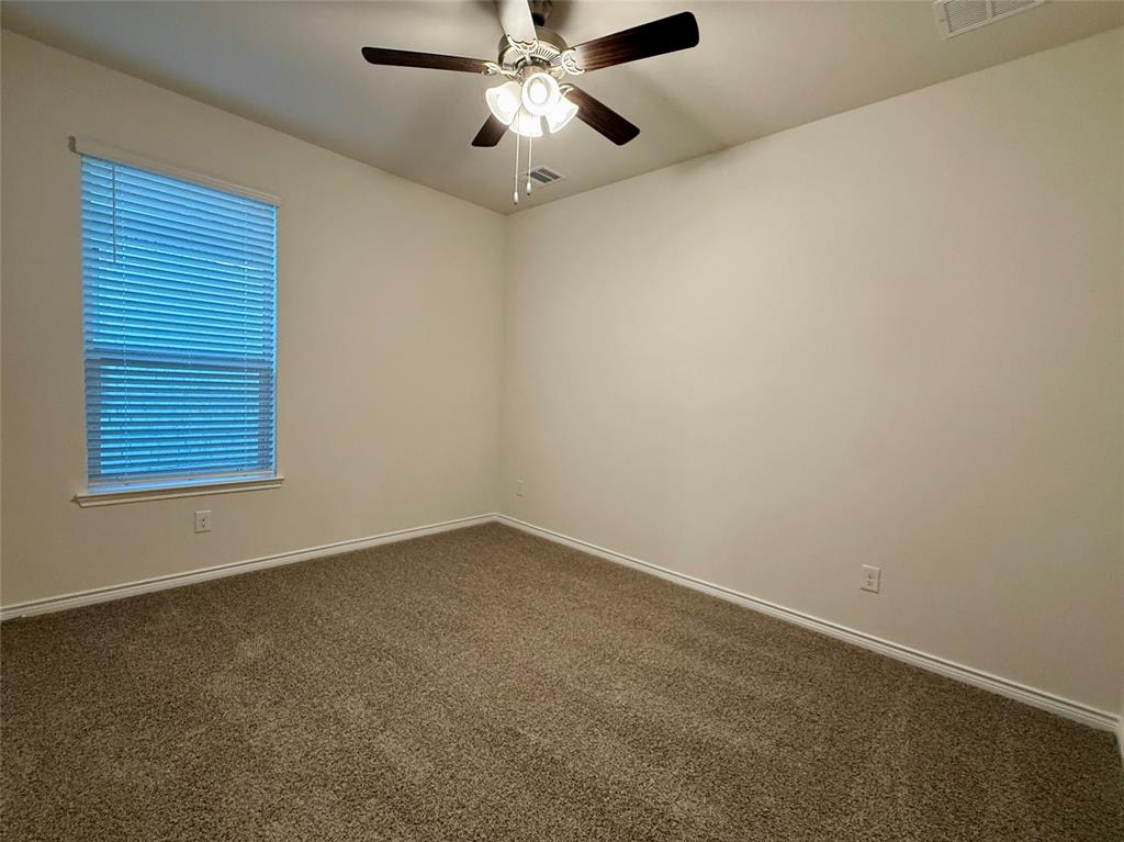 2025 Eugene Street Anna, TX 75409 - Photo 21 of 32 an empty room with a window and a ceiling fan