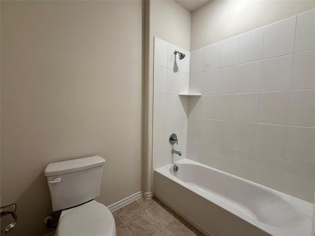 2025 Eugene Street Anna, TX 75409 - Photo 23 of 32 a white toilet sitting next to a bath tub