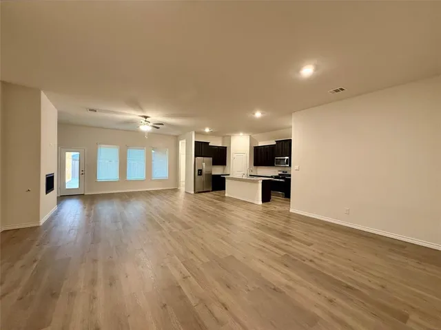 a kitchen island with granite countertop a sink cabinets and wooden floor