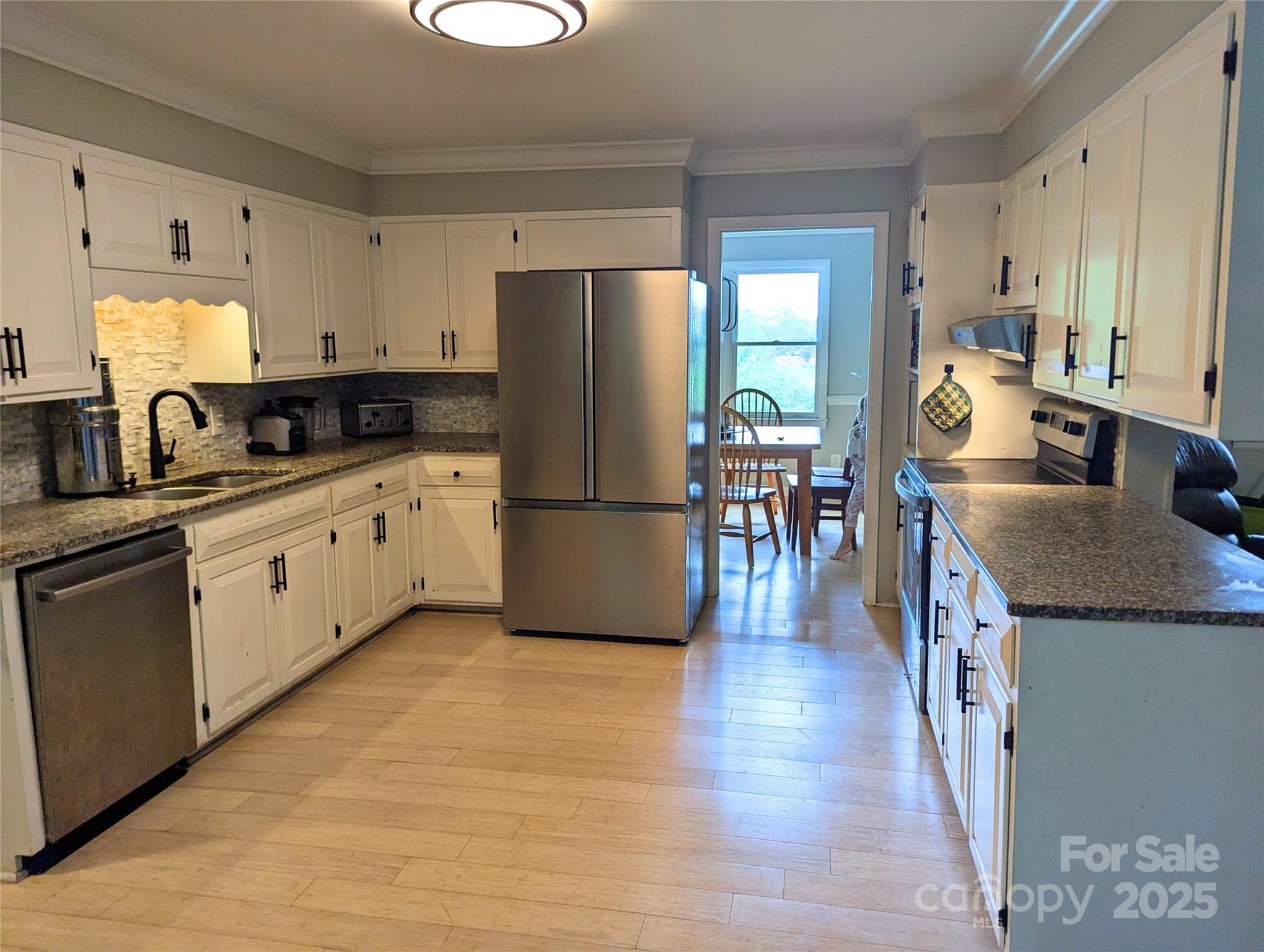 1737 Whiteside Road Forest City, NC 28043 - Photo 5 of 18 a kitchen with granite countertop a refrigerator a stove top oven a sink dishwasher and dining table with wooden floor