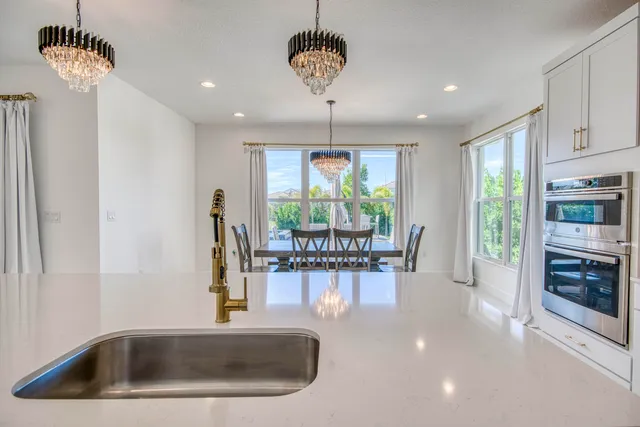 an open kitchen with granite countertop a table and chairs in it