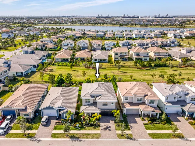a front view of a house with a yard and potted plants