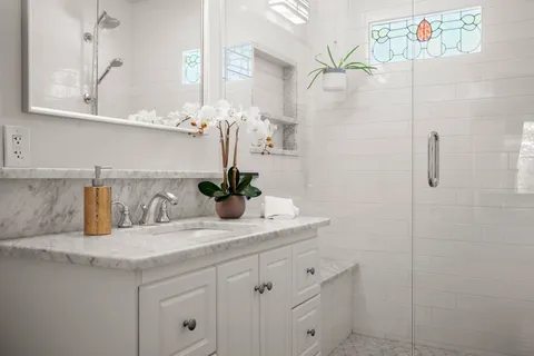 a bathroom with a granite countertop sink a mirror and vanity
