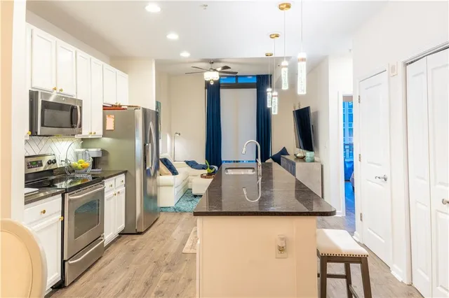 a kitchen with stainless steel appliances granite countertop a refrigerator a stove top oven a sink and dishwasher