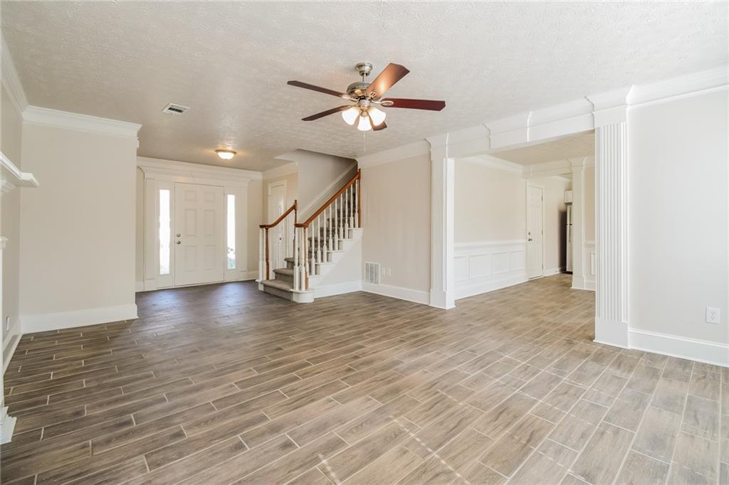 3543 Benthollow Way Duluth, GA 30096 - Photo 12 of 25 a view of a livingroom with wooden floor a ceiling fan and staircase